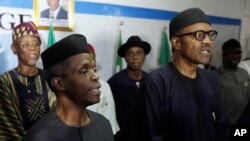 Nigerian former General Muhammadu Buhari, right, along with his deputy, Yemi Osibnajo, sings the national anthem after speaking to journalists in Abuja, Nigeria, April 1, 2015. 