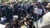 Seorang mahasiswa membawa kertas bertuliskan dukungan pengesahan RUU P-KS pada aksi di depan gedung DPRD Jawa Timur (foto Petrus Riski-VOA).