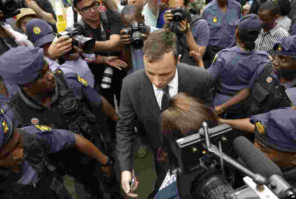 Oscar Pistorius is escorted by police officers as he leaves the high court in Pretoria, South Africa,&nbsp; Oct. 15, 2014. 