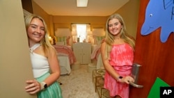 Childhood friends Sydney Allbritton, 18, left, and Emma Kirk, 19, both of Grenada, Mississippi, pose in their decorated dorm room at the University of Mississippi, in Oxford, on Aug. 30, 2023.