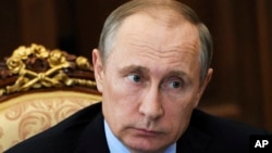 FILE - Russian President Vladimir Putin listens during a meeting at the Kremlin, in Moscow, Russia.