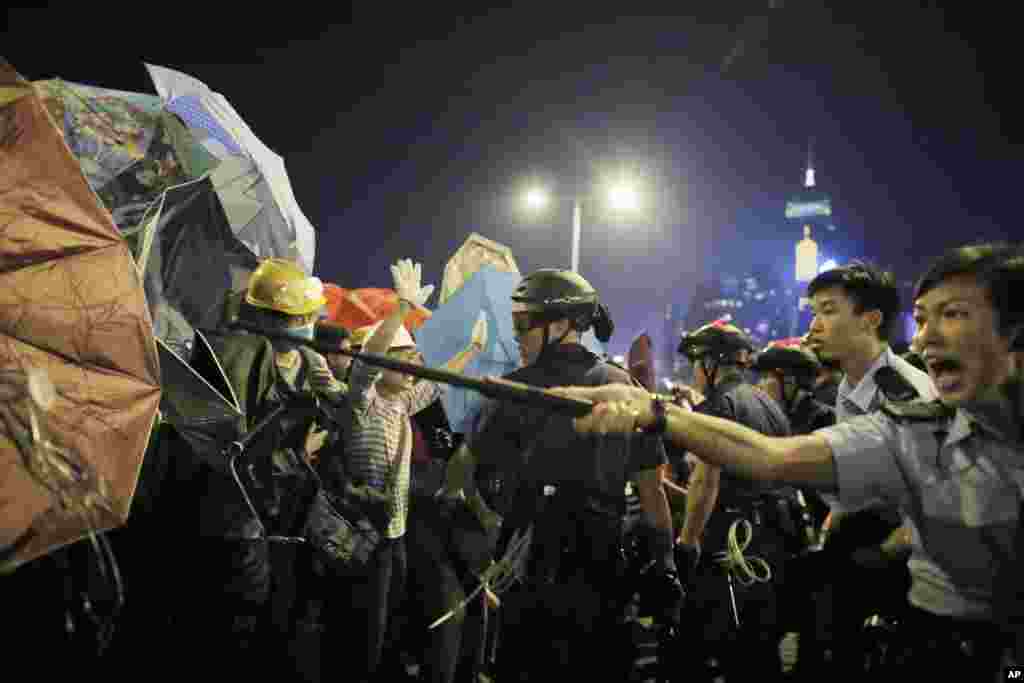 Polisi bentrok dengan demonstran di luar kantor-kantor pusat pemerintahan di Hong Kong (30/11). &nbsp;(AP/Vincent Yu)