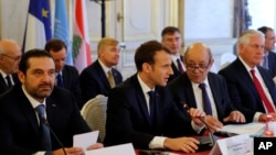 Presiden Perancis Emmanuel Macron duduk di antara Perdana Menteri Lebanon Saad Hariri (kiri), Menteri Luar Negeri Prancis Jean-Yves Le Drian dan Sekretaris Negara AS Rex Tillerson (kanan) dalam pertemuan di Paris, Jumat, 8 Desember 2017.