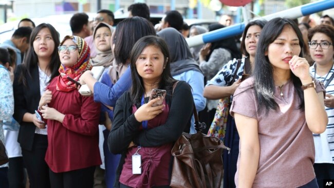 Nhân viên văn phòng sơ tán sau một trận động đất lớn ở thủ đô Jakarta, Indonesia, ngày thứ Ba 23/1/2018. (AP Photo/Achmad Ibrahim)