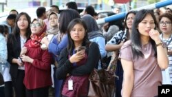 Orang-orang berkumpul saat mereka mengungsi setelah gempa kuat mengguncang Jakarta, Selasa, 23 Januari 2018. (AP Photo / Achmad Ibrahim)