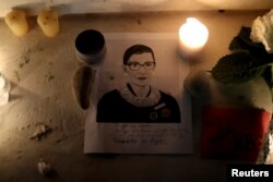 Candles and an image of late U.S. Supreme Court Justice Ruth Bader Ginsburg are seen as people gather in front of the U.S. Supreme Court following her death, in Washington, Sept. 19, 2020.