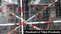 Người dân cài hoa hồng lên hàng rào kẽm gai trước đó được dùng để quây khu vực "trại giam" của công an ở Công viên Tao Đàn, quận 1 TP HCM. (Facebook Lê Thiệu)