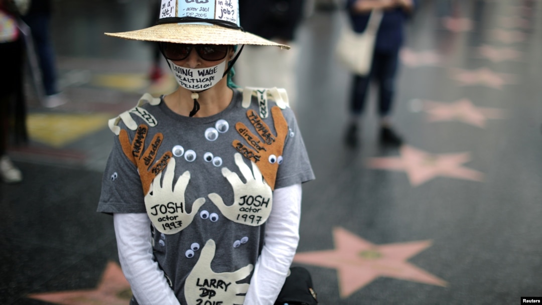 FILE - A woman wearing an outfit with the names of men in Hollywood she claims sexually harassed her, is seen during a protest march for survivors of sexual assault and their supporters, in Hollywood, Los Angeles, California, Nov. 12, 2017.