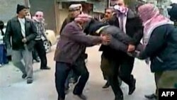 Demonstranti u jednom od predgrađa Damaska nose povređenog učesnika demonstracija,. Autentičnost snimka nije bilo moguće proveriti.