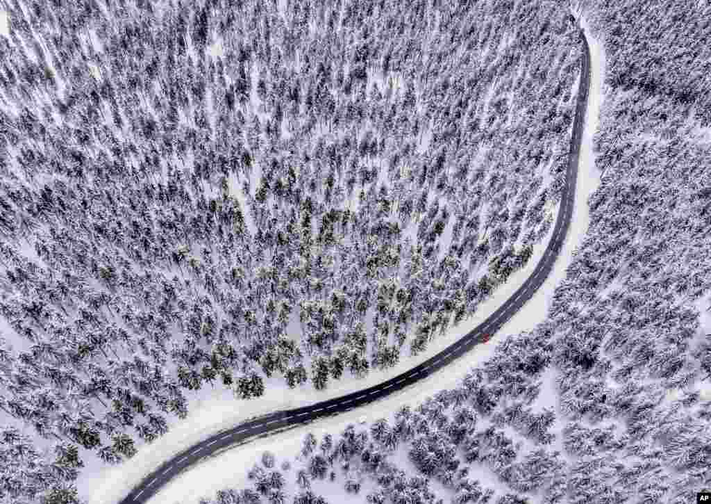 A road leads through the snow-covered Taunus forest near Frankfurt, Germany.