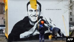 Сотрудник муниципалитета Санкт-Петербурга закрашивает граффити с изображением российского оппозиционера Алексея Навального, 28 апреля 2021 года