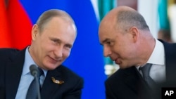 Russia's Finance Minister Anton Siluanov (R), seen in this May 8, 2015 photo with President Putin, on Thursday told Russian media that Moscow is ready to consider Ukraine's debt proposals but warned that time is running out.