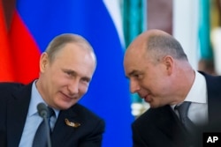Russia's Finance Minister Anton Siluanov (R), seen in this May 8, 2015 photo with President Putin, countered Lukashenko's comments by declaring a "loss of trust lately" with Moscow's closest historical ally.