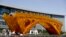 Workers install wires on a Golden Bridge of Silk Road structure on a platform outside the National Convention Center, the venue which will hold the Belt and Road Forum for International Cooperation, in Beijing, April 18, 2017.