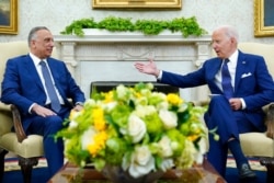 FILE - President Joe Biden, right, speaks as Iraqi Prime Minister Mustafa al-Kadhimi listens during their meeting in the Oval Office of the White House in Washington, July 26, 2021.