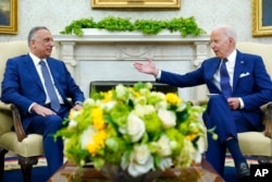FILE - President Joe Biden, right, speaks as Iraqi Prime Minister Mustafa al-Kadhimi listens during their meeting in the Oval Office of the White House in Washington, July 26, 2021.