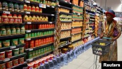 Une femme fait ses courses dans un magasin du centre commercial Dobson Point, à Soweto, en Afrique du Sud, le 19 mars 2024. Reuters / Siphiwe Sibeko
