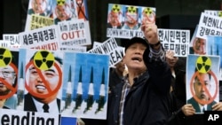 South Korean protesters holdr pictures of North Korean leader Kim Jong Un, national founder the late Kim Il Sung and late leader Kim Jong Il during a rally against recent missile launches and provocative acts in Seoul, South Korea, April 15, 2014.