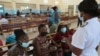 A nurse speaks to people waiting to be vaccinated with a COVID-19 vaccine at a public hospital in Harare, Zimbabwe, Dec. 1, 2021. 