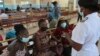 A nurse speaks to people waiting to be vaccinated with a COVID-19 vaccine at a public hospital in Harare, Zimbabwe, Dec. 1, 2021. 