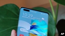 The new Huawei Mate 40 Pro smartphone is held for a photo, in London, Wednesday Oct. 21, 2020. Huawei, has unveiled its Mate 40 line of phones, Thursday Oct. 22, 2020, a product release that comes at a crucial moment for the company. (AP Photo/James…