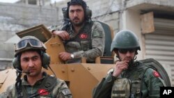 FILE - Turkish soldiers atop an armored personnel carrier secure the streets of the northwestern city of Afrin, Syria, March 24, 2018.