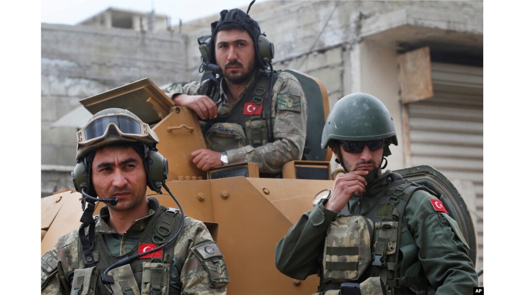 FILE - Turkish soldiers atop an armored personnel carrier secure the streets of the northwestern city of Afrin, Syria, March 24, 2018.