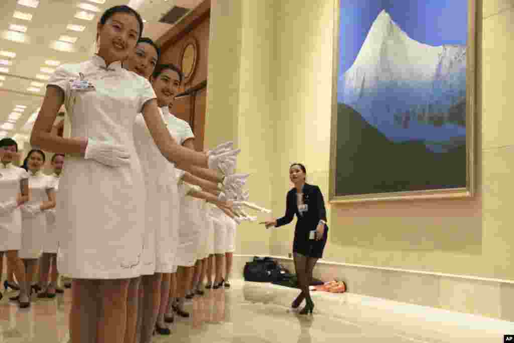 Hostesses pose for photos during a break from the G20 Finance Ministers and Central Bank Governors meeting in Chengdu in Southwestern China&#39;s Sichuan province.
