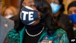 Rep. Terri Sewell, D-Ala., wears a pin honoring John Lewis while standing alongside other members of the Congressional Black Caucus speaking in front of the Senate chambers about voting rights legislation at the Capitol in Washington, Jan. 19, 2022.