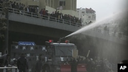 Protesters calling themselves the "Youth of March 24 Movement" demonstrate to demand for political reform and the ouster of the prime minister in front of police water canons at a main square in Amman, March 25, 2011