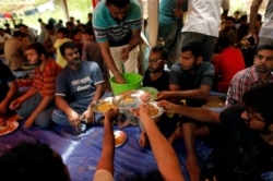FILE - Ahmadi refugees from Pakistan eat at the Ahmadiyya Muslim Community Center in Pasyala, Sri Lanka, April 26, 2019.