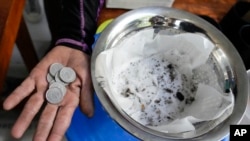 Michael Labag shows the 9 pesos reward he got from the 45 mosquito larvae he captured in Mandaluyong city, Philippines, as part of an anti-dengue campaign on Wednesday, Feb. 19, 2025.