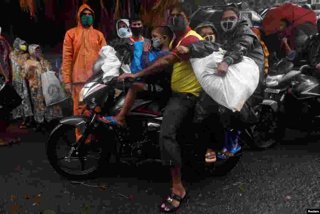 A man and his family ride a motorbike during an evacuation of a slum off the coast of the Arabian sea as cyclone Nisarga makes its landfall, in Mumbai, India.