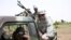 Malian troops and their U.S. Special Forces instructor await the start of a live-fire drill in Kita, Mali, during a joint training exercise with a unit of elite Malian troops, May 10, 2010.