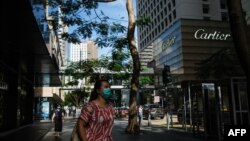 行人佩戴口罩走過香港中環的街道。（2020年7月16日）