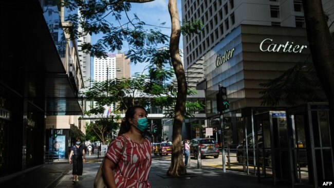 行人佩戴口罩走过香港中环的街道。（2020年7月16日）