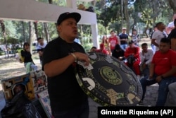 Jonathan Rulleri, the founder of Poleanas Canada Frogs, holds up a poleana board to be raffled off before the start of a tournament in Mexico City, Sunday, Nov. 17, 2024. (AP Photo/Ginnette Riquelme)