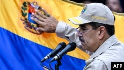 ARCHIVO: El presidente venezolano, Nicolás Maduro, toca una bandera durante un evento político celebrado en Caracas el 10 de diciembre de 2024. La Casa Blanca desconoció la victoria del aspirante a la reelección en julio y llama "presidente electo" al abanderado de la oposición.