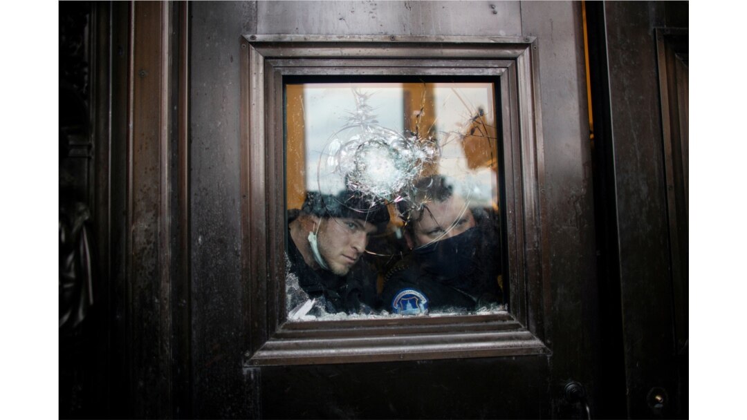Members of the Capitol Police look through a smashed window as pro-Trump protesters rally to contest the certification of the 2020 U.S. presidential election results by the U.S. Congress, at the U.S. Capitol Building in Washington, Jan. 6, 2021.