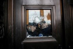 Members of the Capitol Police look through a smashed window as pro-Trump protesters rally to contest the certification of the 2020 U.S. presidential election results by the U.S. Congress, at the U.S. Capitol Building in Washington, Jan. 6, 2021.