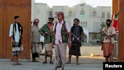 Armed men loyal to Yemen President Abd-Rabbu Mansour Hadi stand guard outside a local authority compound after taking it over in Yemen's southern port city of Aden, Feb. 16, 2015.