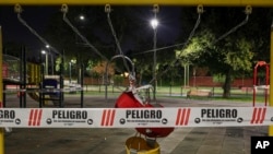 A swing set at a public playground area is closed with security tape that reads 'Danger' in Spanish as a precautionary measure against the spread of the new coronavirus, in Santiago, Chile, March 26, 2020.