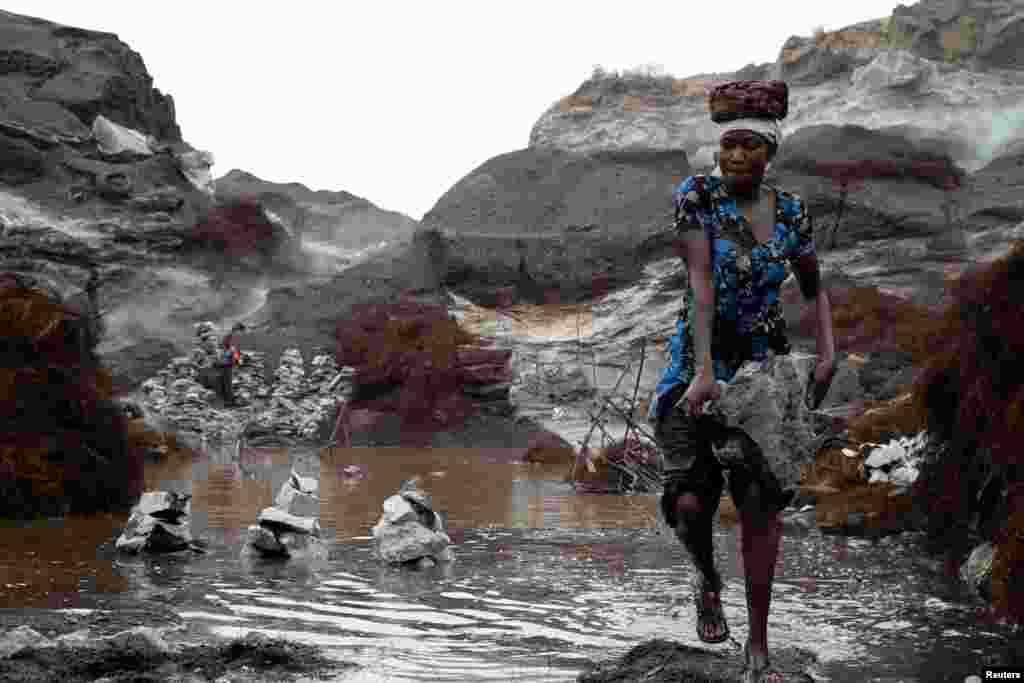 A woman carries stones in Pissy informal granite quarry in Ouagadougou, Burkina Faso.