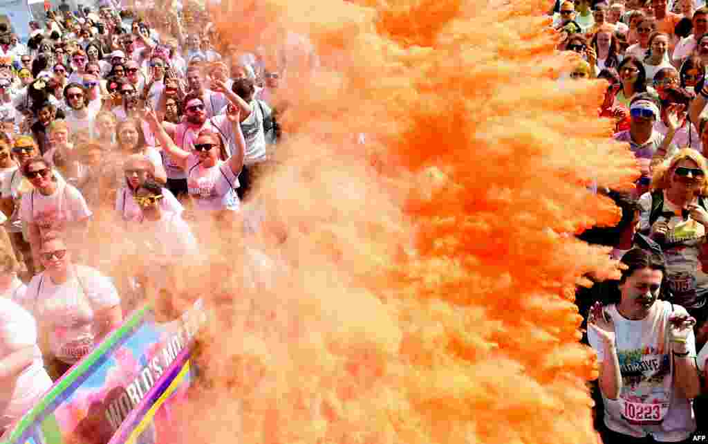 Participantes estão cobertos de pintura de pó ao preperar-se a participar na corrida &quot;Run or Dye&quot; em Aintree Racecourse em Liverpool, no noroeste da Inglaterra, 6 de Junho, 2015.