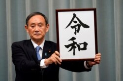 Japan's Chief Cabinet Secretary Yoshihide Suga unveils 'Reiwa' as the new era name at the prime minister's office in Tokyo, Japan, April 1, 2019.