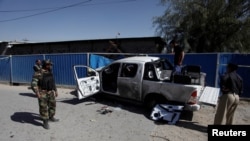 Police officers inspect a pickup damaged by a suicide bomber which killed a senior Pakistani police official on his way to work in Quetta, Pakistan, Nov. 9, 2017. 