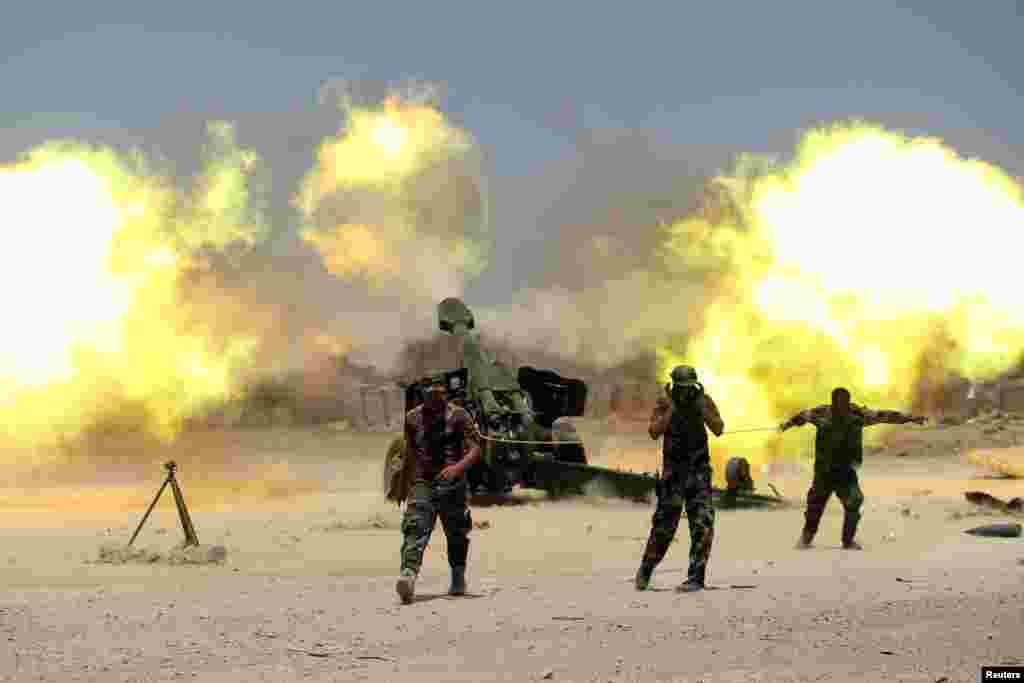 Pejuang Syiah dan pasukan keamanan Irak menembakkan artileri mereka dalam perang melawan militan Negara Islam (ISIS) dekat Fallujah, Irak (29/5). (Reuters/Alaa Al-Marjani)