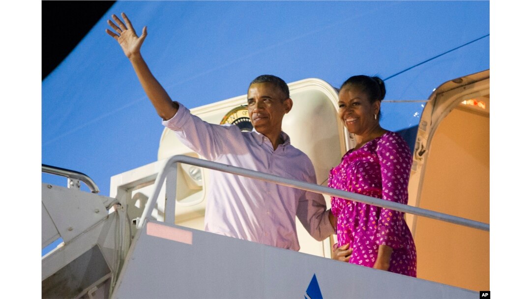 FILE - President Barack Obama, left, and first lady Michelle Obama wave as they board Air Force One to depart from Joint Base Pearl Harbor-Hickam at the end of their family vacation, Jan. 2, 2016, in Honolulu, Hawaii.