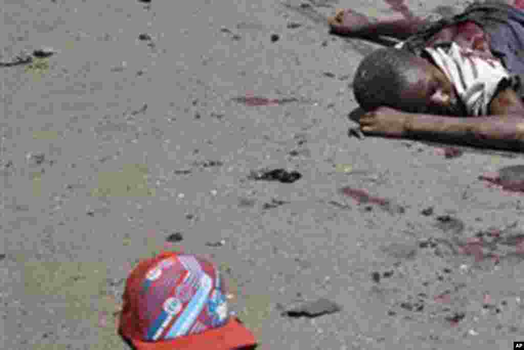 The body of a victim of a bomb explosion lies in the street in Kaduna, Nigeria,Thursday, April. 26, 2012.