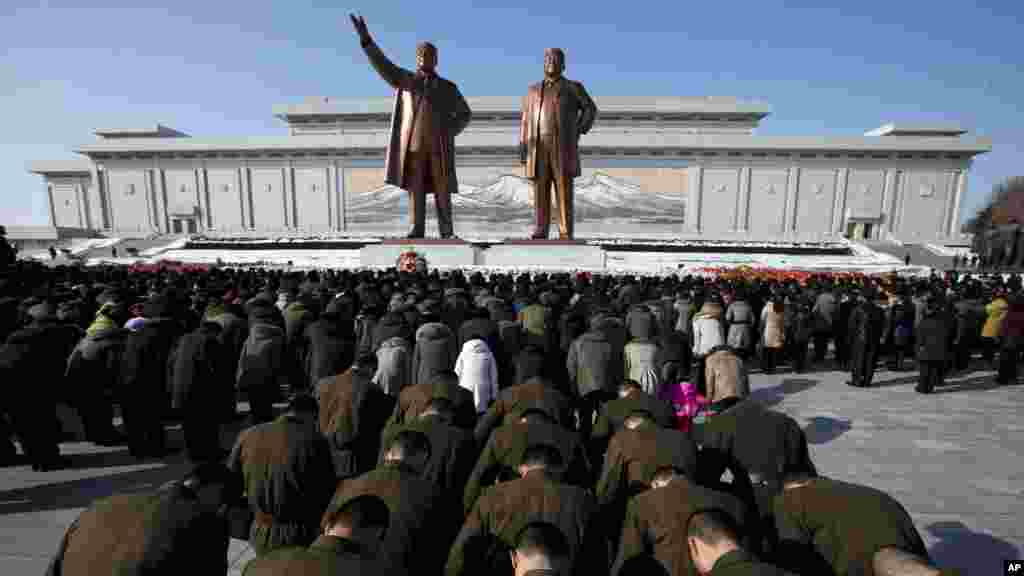 North Korean soldiers bow before the statues of late leaders Kim Il Sung, left, and Kim Jong Il, right, at Mansu Hill in Pyongyang, North Korea, December 17, 2012.